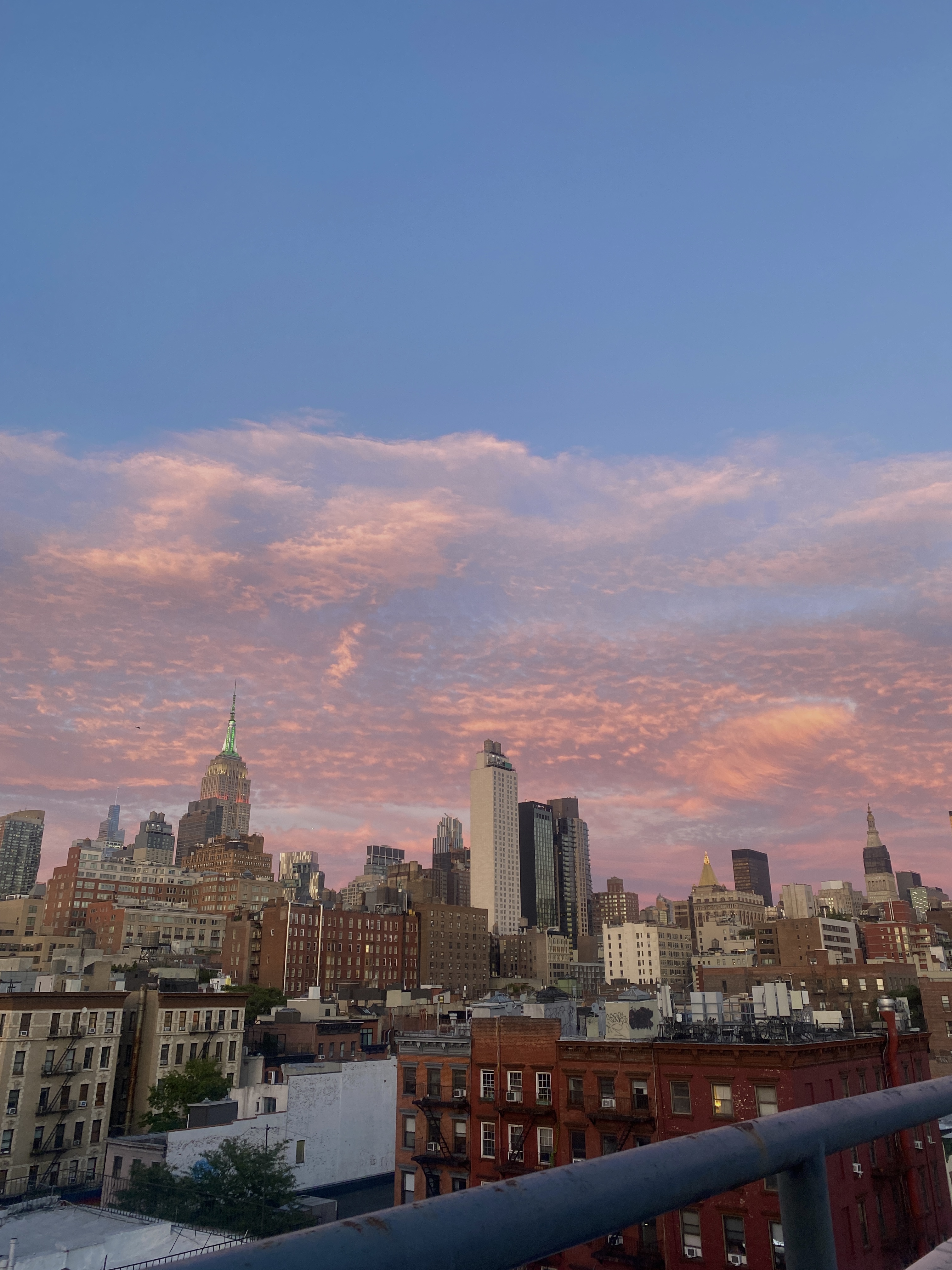 An image of the sunset over the Manhattan skyline taken from a roof.